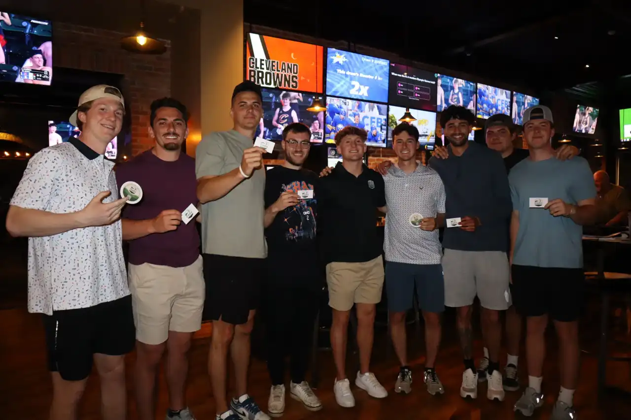 Group of young men holding prize tokens at a Lorain sports bar event
