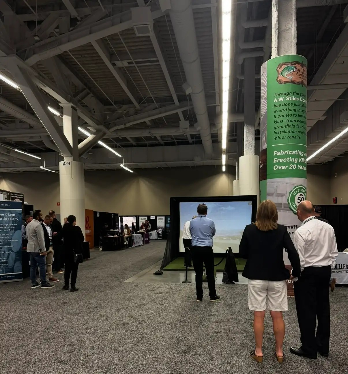 Attendees gathered around the Mr. Caddie Events golf simulator on a trade show floor