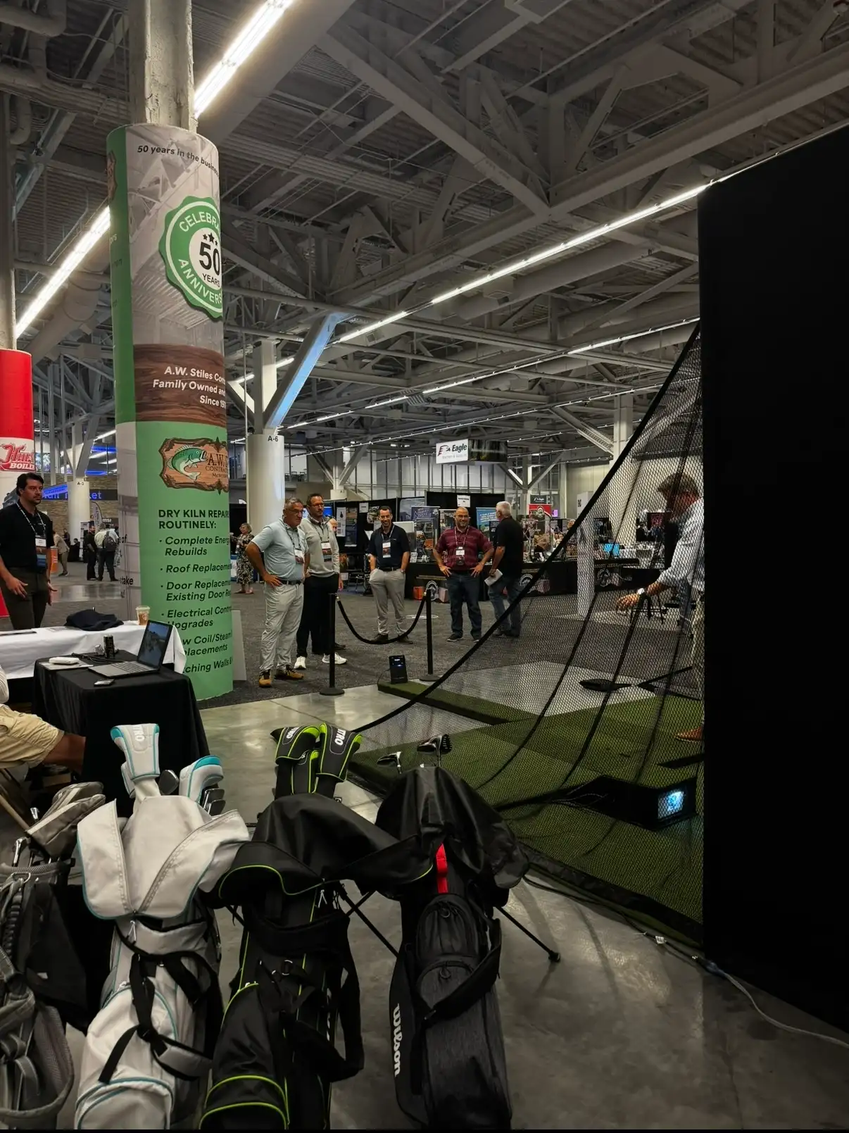 Mr. Caddie Events golf simulator bay and club bags set up at a trade show