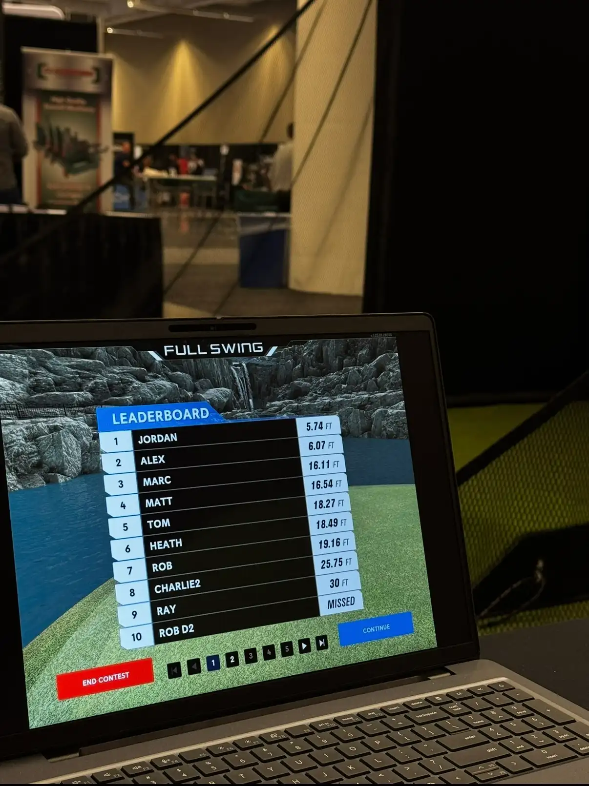 Full Swing leaderboard on a laptop beside the Mr. Caddie Events simulator